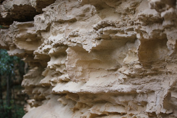 Texture light sand rock, overhanging layers. Sand-colored limestone, natural wall