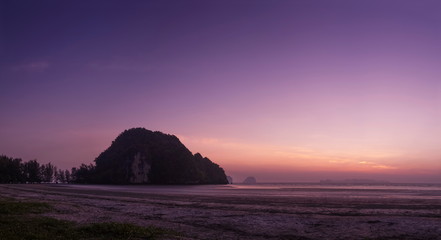 Fototapeta premium view seaside evening of mountain on sand beach with purple sky background, twilight at Chao Mai beach, Had Chao Mai National Park, Trang Province, southern of Thailand.