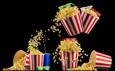 Set of striped buckets with popcorn, cup of drink and glasses isolated on black