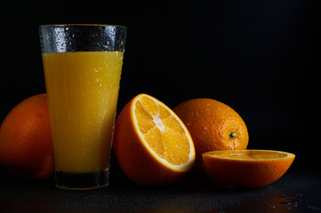 orange juice in a glass on a black background close-up