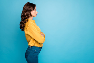 Profile photo of amazing curly business lady hold hands crossed seriously looking colleagues dislike coming work late wear yellow shirt trousers isolated blue color background