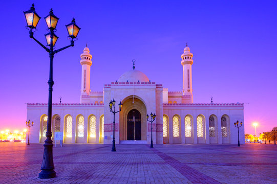 Beautiful architecture of Al Fatch Grand Mosque with lights on early morning over blue sky background, Manama Bahrain