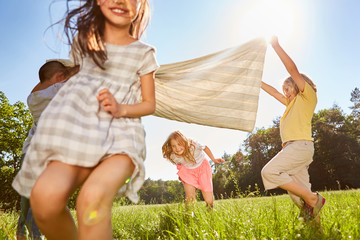 Children play and run across a meadow