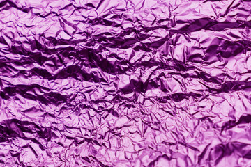 Fototapeta premium Purple crumpled sheet of aluminum foil. Foil background.