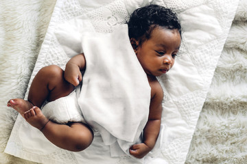 Portrait of cute adorable little african american baby sleep in a white bedroom