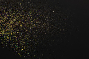 Gold glitter on black background. Holiday abstract texture