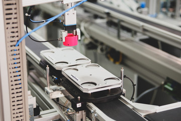 close-up of Gripper, picks up the product from automated car which is on the manufacturing line in a smart factory. Industry 4.0 concept; artificial intelligence in manufacturing.