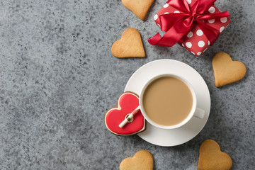Valentines day greeting card with heart cookies and coffee cup on grey stone table.