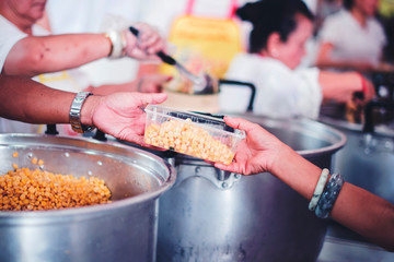 The concept of food shortage, hungry people offer food donations from volunteers who have donated free charity food.