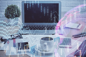 Stock market graph on background with desk and personal computer. Multi exposure. Concept of financial analysis.