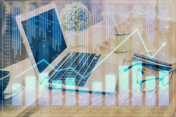 Double exposure of chart and financial info and work space with computer background. Concept of international online trading.