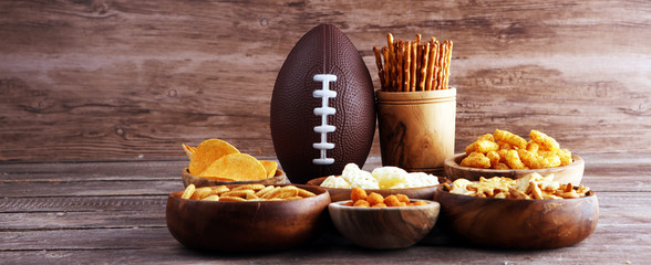 Chips, salty snacks, football on a table. Great for Bowl Game snack projects. - obrazy, fototapety, plakaty
