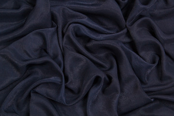 The fabric is blue silk. Blue textile drapery