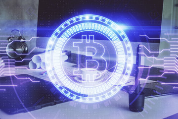 Double exposure of blockchain theme hologram and table with computer background. Concept of bitcoin crypto currency.