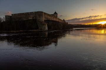 Fototapeta na wymiar Beautiful winter dawn over the river and the fortress. Noise effect applied