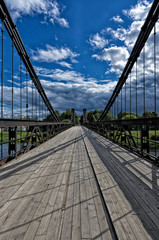Chain cable-stayed bridge against a beautiful blue sky with clouds (Ostrov, Pskov oblast, Russia) vertical orientation