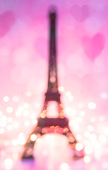 Valentine's day abstract background with Eiffel tower on pink background with hearts and lights. Vertical picture, defocused