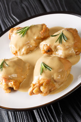 Holy Yum Chicken thighs in mustard maple sauce close-up in a plate. vertical