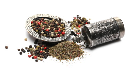 Peppercorns in embroidered, embossed decorative pot, bowl with silver mill isolated on white...