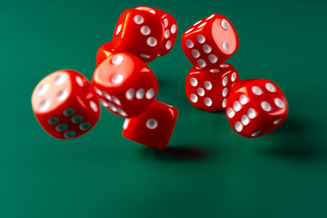 Red dice on green background close up