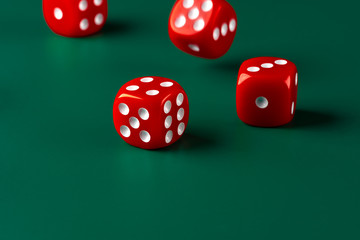 Red dice on green background close up
