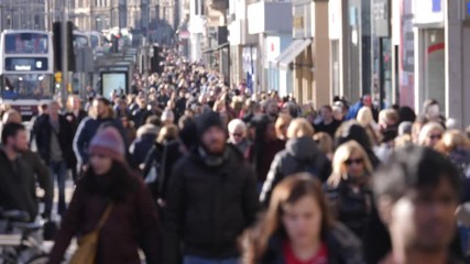 Anonymous / Unrecognisable People walking on Princes Street, Edinburgh. They are shopping and walking. Blurred. Slow motion.