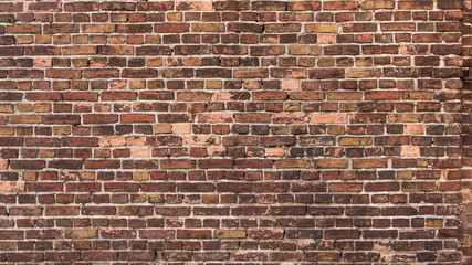 Beautiful old brick wall. An ancient barn wall. Brick wall background texture.