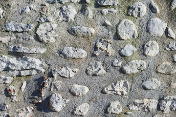 The stony wall texture background made of big wild rocky stones bonded by the cement in one construction