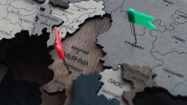 hand pin a flag to Myanmar country. wooden world map in Russian. Myanmar cities with colorful pins on a wooden map. The concept of travel, holiday in Asia. Pushpin on Naypyidaw.