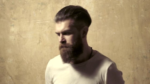 Studio shot of young man looking at the camera. Handsome fashion man hipster. Good morning. Hair model. Fashion male model.