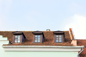 Obraz premium tiled red orange roof of the house with skylights