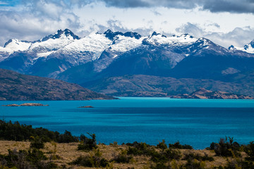 Fototapeta premium Snow capped mountains Snow capped mountains and blue lake of General Carrera in Chilean Patagoniaand blue lake