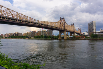 Fototapeta na wymiar Queensboro Bridge connects Long Island City in the borough of Queens with the neighborhood of the Upper East Side Manhattan, passing over Roosevelt Island.