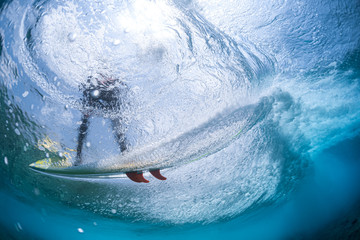 Underwater view of the surfer riding the wave