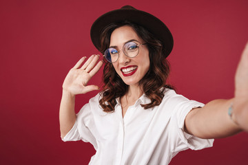 Woman in glasses take a selfie by camera.