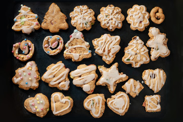 Christmas or New Year cookies on a dark background. in the form of a Christmas tree, New Year's star, New Year's hear, New Year's pretzel. Homemade baking.