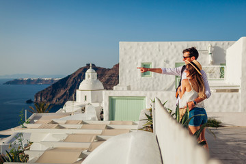 Santorini vacation, Greece honeymoon. Couple in love walking in Fira. Man and woman enjoying sea landscape.