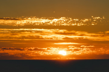orange sunset over the Indian Ocean in Perth sun shining through low clouds over the horizon