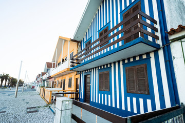 Obraz premium Colorful striped fishermen beach houses (Palheiros) with yellow, red, blue and green stripes in Costa Nova Portugal, a resort town near Aveiro