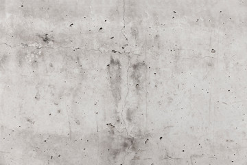 Light gray concrete wall with cracks and holes. Background texture.