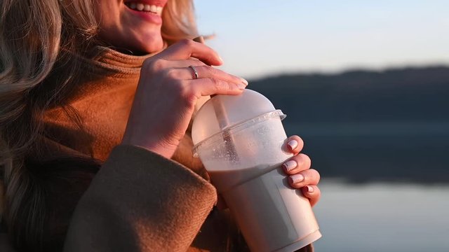 Young woman mix coffee with a bamboo straw and drink it