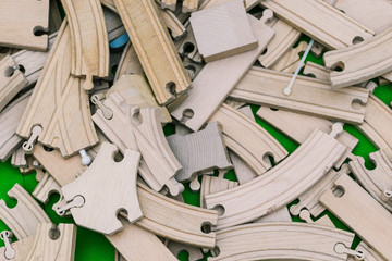 Wooden ecological constructor blocks. The rails from the children's railway are scattered on the floor. Ecological toys.