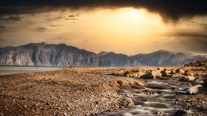Long exposure of the coastline of Pond Inlet in summer over mountaing and dramatic sky in Baffin...