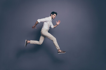 Full size profile side photo of cheerful guy jump run after luxury black friday bargain have fun wear modern clothing isolated over grey color background