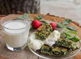 Close up of pie with spinach on transperent glass plate with white cream, radish and yogurth.