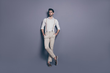 Full body photo of imposing guy stand copy space isolated over grey wall background put hands pocket stare want attract beauty woman wear stylish clothing