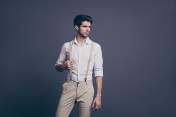 Fototapeta premium Portrait of serious minded guy rich wealthy millionaire attract woman ideal man concept touch his suspenders stare copy space wear classy outfit isolated over grey color background