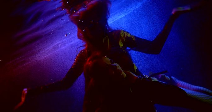 unusual subaquatic night club, two girls are floating underwater