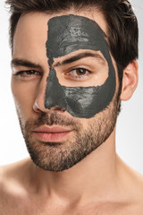 Photo of sexual half-naked man with cosmetic clay mask on his face
