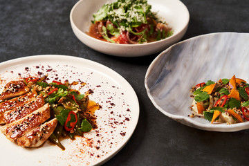 Set of various plates of food on a gray table background with copy space